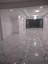 Corridor with light marble finish floors, recessed lighting, and a raised ceiling