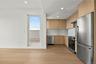 Kitchen with modern cabinets, appliances with stainless steel finishes, recessed lighting, light wood-type flooring, and light brown cabinets