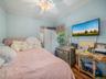Bedroom with ornamental molding, wood finished floors, and a ceiling fan
