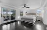 Bedroom featuring crown molding, access to outside, dark wood-style floors, ceiling fan, and a raised ceiling