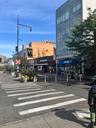 View of asphalt street with traffic signs, street lights, sidewalks, and curbs