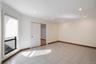 Bright room featuring light-toned tile flooring, recessed ceiling lighting, and a window with a roller shade