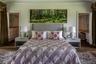 Bedroom featuring ensuite bathroom, dark wood finished floors, crown molding, and multiple windows