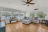 Living room with healthy amount of natural light, a ceiling fan, a water view, vaulted ceiling, and light wood-style floors