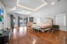 Bedroom featuring french doors, wood finished floors, vaulted ceiling, access to exterior, and a raised ceiling