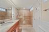 Bathroom featuring vanity, tile patterned flooring, recessed lighting, and a tile shower