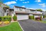Contemporary residence featuring a light gray exterior with brick accents and a dark brown roofline