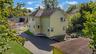 View of side of property with a patio and a shingled roof