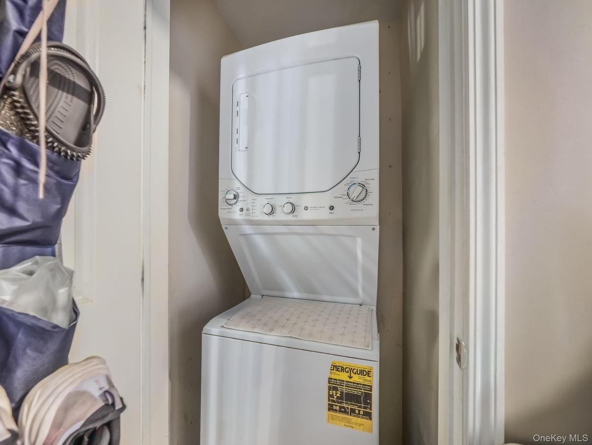 Washroom featuring stacked washer and clothes dryer