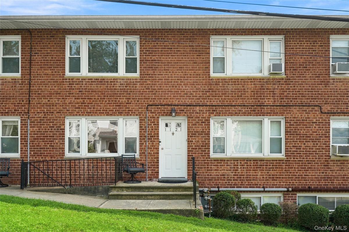 Inviting brick exterior with sun-drenched multi-pane windows and a covered entry stoop