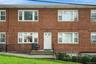 Inviting brick exterior with sun-drenched multi-pane windows and a covered entry stoop