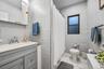 Bathroom with vanity, tile walls, and a shower with shower curtain