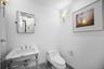 Half bath featuring marble finish flooring and toilet