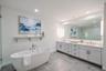 The primary bathroom features a sophisticated double vanity with an expansive quartz countertop, dual undermount sinks, and abundant drawer storage. S