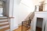 Hardwood flooring throughout, featuring a staircase with wrought iron railings and wood treads