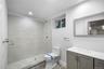 Bathroom with a shower stall, vanity, and recessed lighting