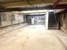 Unfinished basement featuring stairs and water heater