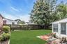 Expansive backyard featuring a manicured lawn, wood fencing, and mature trees detached Garage and Greenhouse