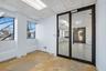 Empty room with a paneled ceiling and concrete flooring
