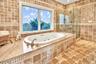 Second Floor Primary Bathroom en-suite with tile walls, a tub with jets, and a shower stall
