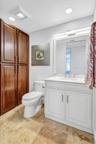 Residence Secondary / Guest Bedroom sink basin with large white cabinetry and stainless steel handles. Matching mirror and modern lighting