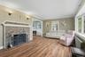 Living area with ornamental molding, a fireplace, radiator, and wood finished floors