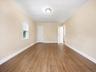 Wood-finish flooring, neutral wall tones, white trim, and a ceiling-mounted light fixture