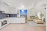 Kitchen with modern cabinets, stainless steel oven, white cabinets, and hanging light fixtures