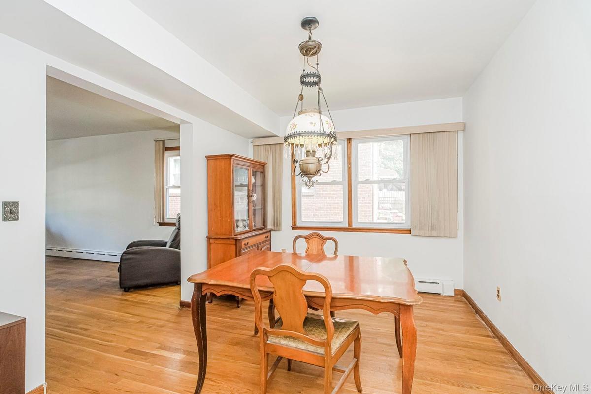Spacious interior with wood-finish flooring, white walls, and an ornate ceiling fixture