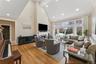 Living area featuring high vaulted ceiling, a fireplace, recessed lighting, and light wood-type flooring