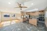 Kitchen featuring stainless steel appliances, a skylight, backsplash, a ceiling fan, and open floor plan