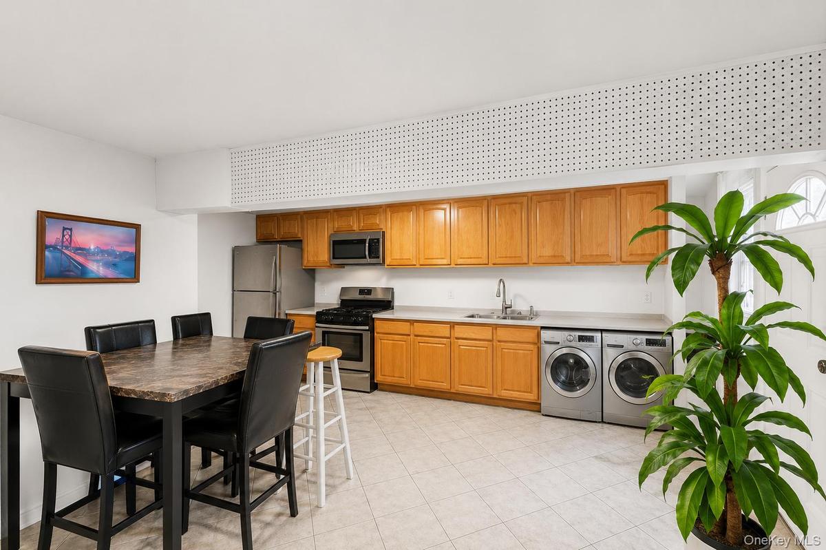Kitchen area featuring wood cabinetry, stainless steel appliances, and a double basin sink