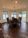 Dining space featuring a notable chandelier, dark wood-style floors, baseboard heating, and ornamental molding