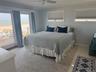 Bedroom with a ceiling fan, ornamental molding, a water view, and baseboards