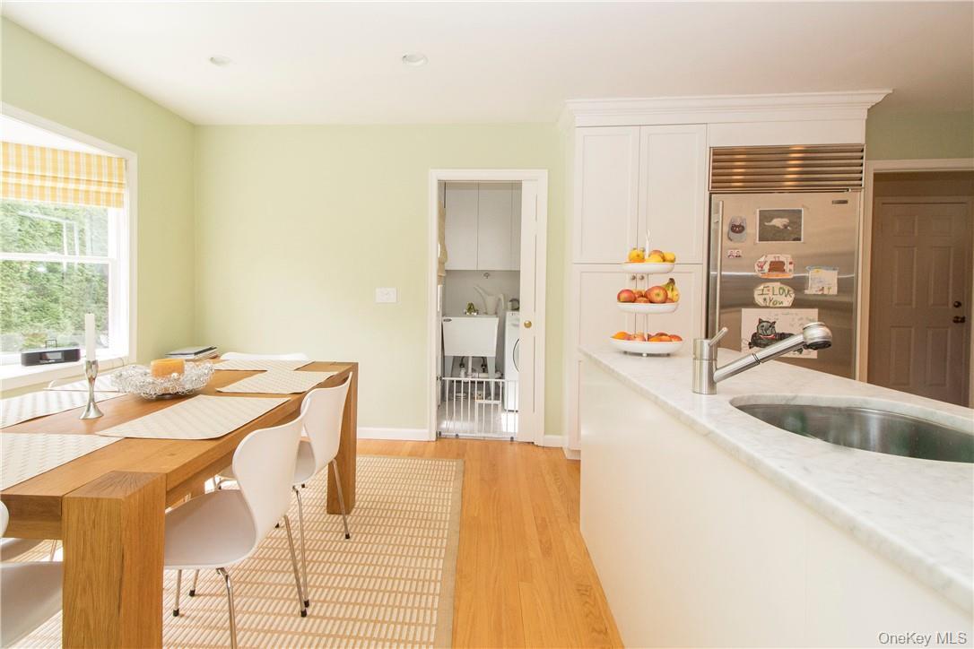 Eat in area of kitchen with bay window and looking towards laundry area and door to patio and backyard