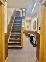 Stairs featuring a wainscoted wall, wallpapered walls, carpet, and wooden walls