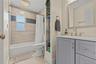 Hall bathroom with updated tile and vanity. Tub shower combo.