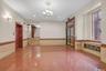 Unfurnished room featuring wainscoting, granite tiled floors, elevator, tile walls, and a chandelier