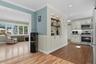 Kitchen featuring dark wood finished floors, backsplash, stainless steel appliances, radiator heating unit, and ornamental molding