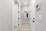 Hallway; garage door on right, mudroom sitting area, laundry door on left