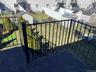 Expansive rear yard featuring green lawn, mature landscaping, privacy fencing, and multiple storage sheds