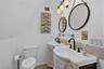 Primary bathroom with modern vanities, decorative mirrors, and stylish fixtures.