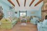 Living area featuring high vaulted ceiling, hardwood / wood-style floors, a stone fireplace, and beam ceiling