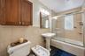 Bathroom featuring a pedestal sink, white toilet, and bidet