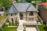 Rear view of property featuring brick siding, a fenced backyard, and roof with shingles