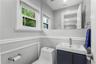 Contemporary bathroom featuring a wall-mounted vanity with integrated sink, chrome faucet, and full-width mirror