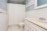 Bathroom featuring a white vanity with integrated sink, chrome faucet, and white paneled wainscoting