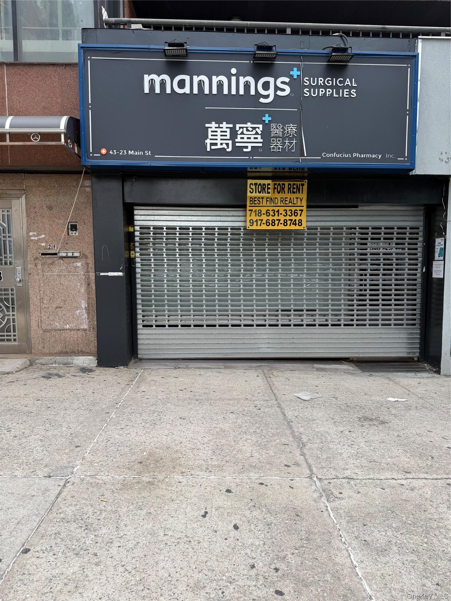 Commercial storefront featuring a roll-down security gate and a prominent illuminated sign