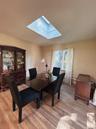 Dining room with a skylight and light wood-type flooring