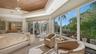 1st Floor Primary suite with picturesque views of the screened lanai, sparkling saltwater pool, and relaxing spa